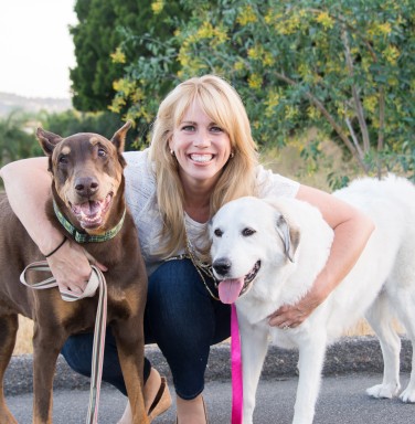 blonde woman between two large dogs