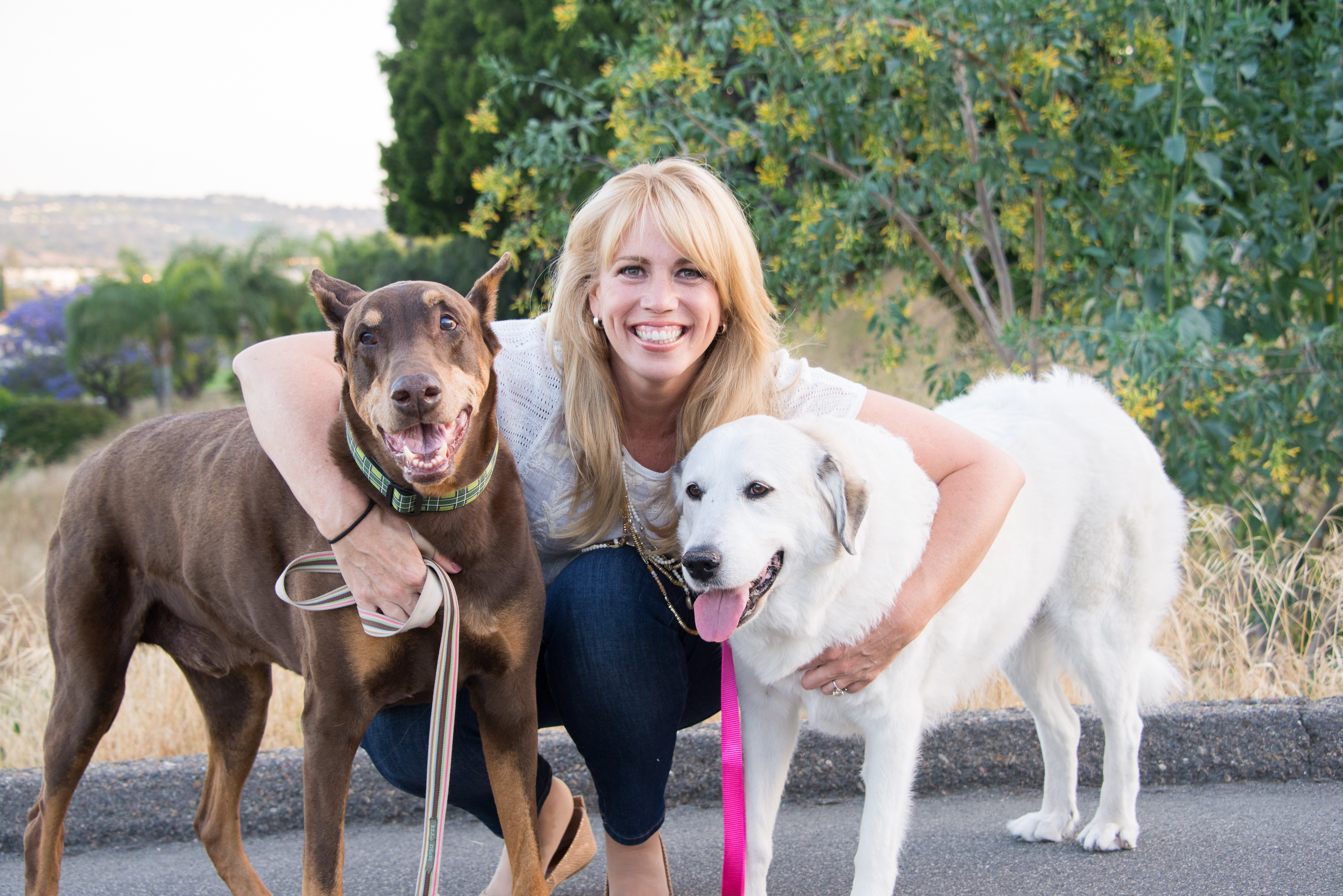 blonde woman between two large dogs