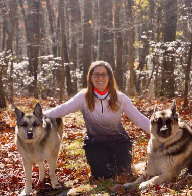 woman with 2 german shepherds in woods