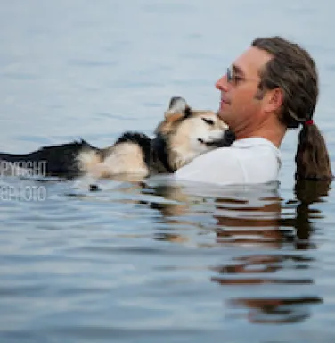 John Unger and Schoep, the dog, relaxing in water