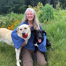Elizabeth with her two dogs, Wilber and Pretzel white haired woman with two dogs in a field