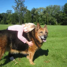Willow, a little girl, hugging her 14-year-old dog Zoe