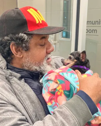 man and dog embracing