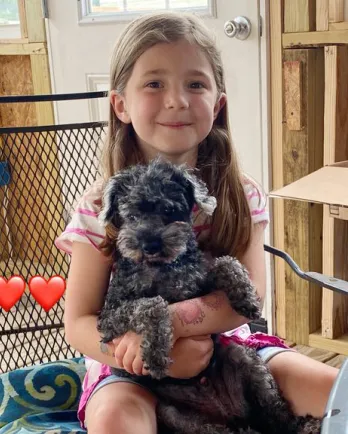 black poodle and young girl