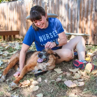 dog and woman playing in the grass