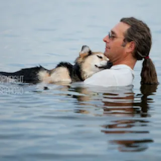 John Unger and Schoep, the dog, relaxing in water